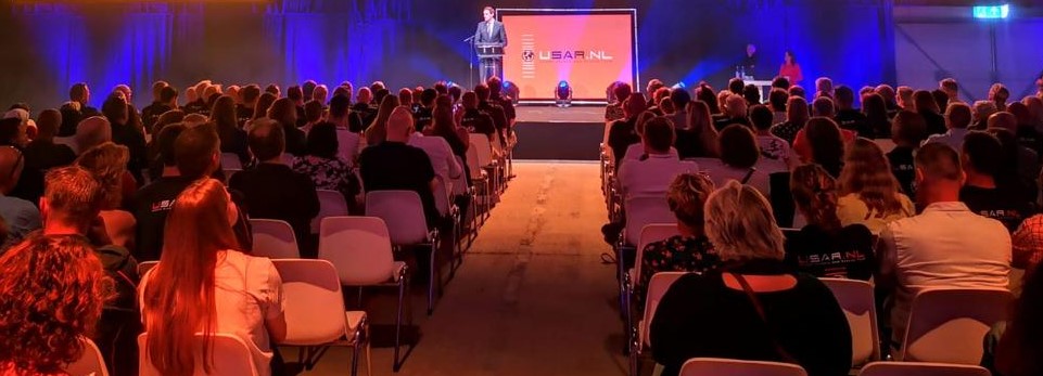 Afbeelding met kleding, persoon, Evenementenzaal, evenement Automatisch gegenereerde beschrijving