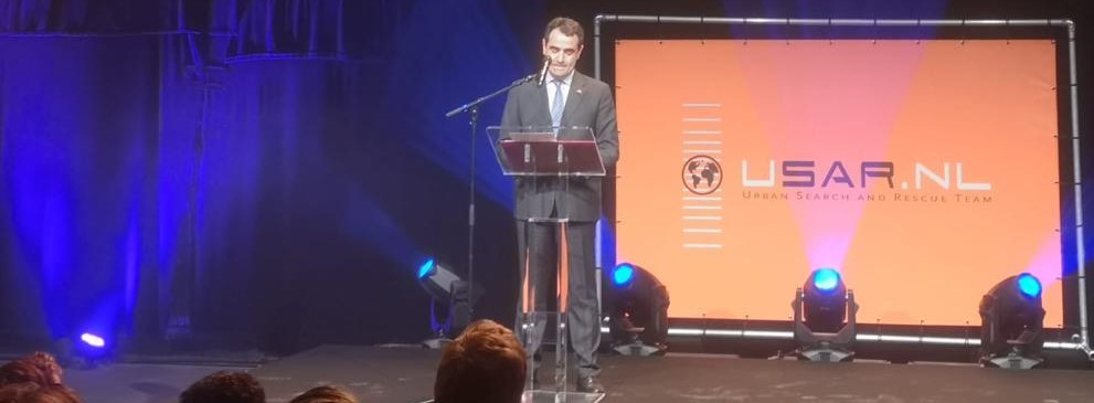 Afbeelding met podium, Podiumapparatuur, persoon, presentatie Automatisch gegenereerde beschrijving