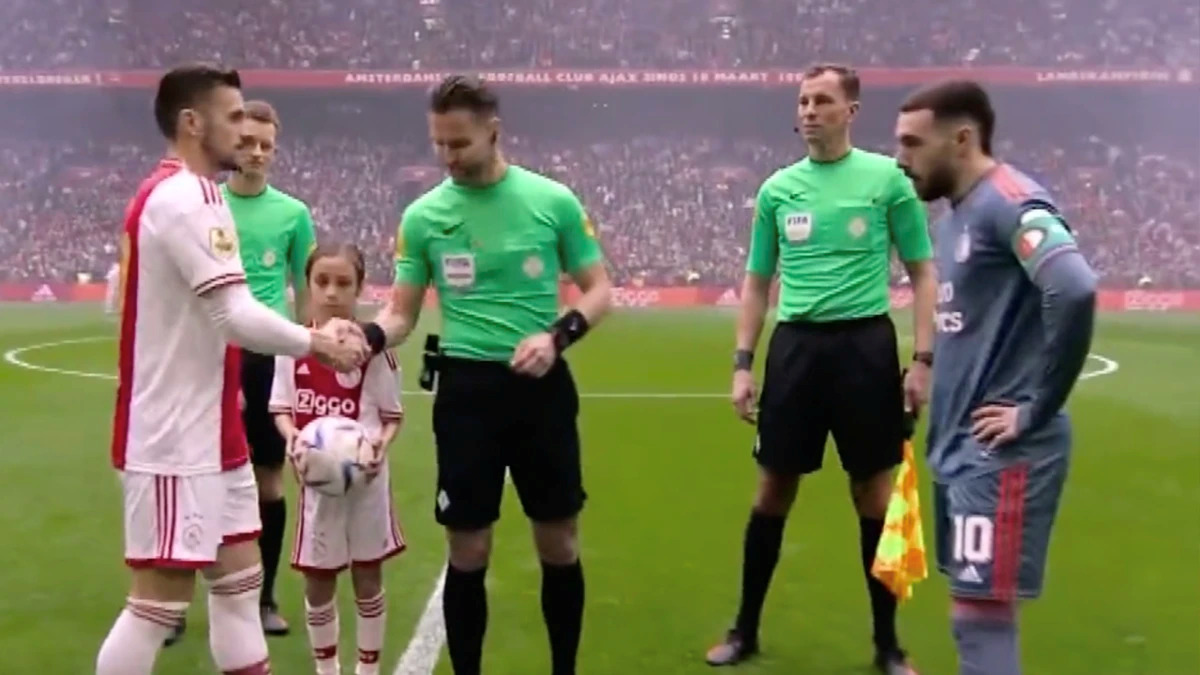 Afbeelding met persoon, gras, voetbalspeler, voetbal Automatisch gegenereerde beschrijving