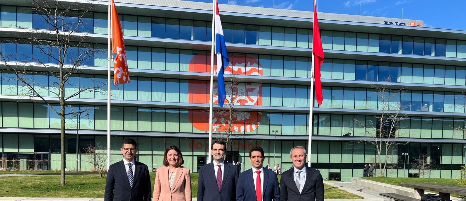 Afbeelding met buitenshuis, pak, person, vlag Automatisch gegenereerde beschrijving