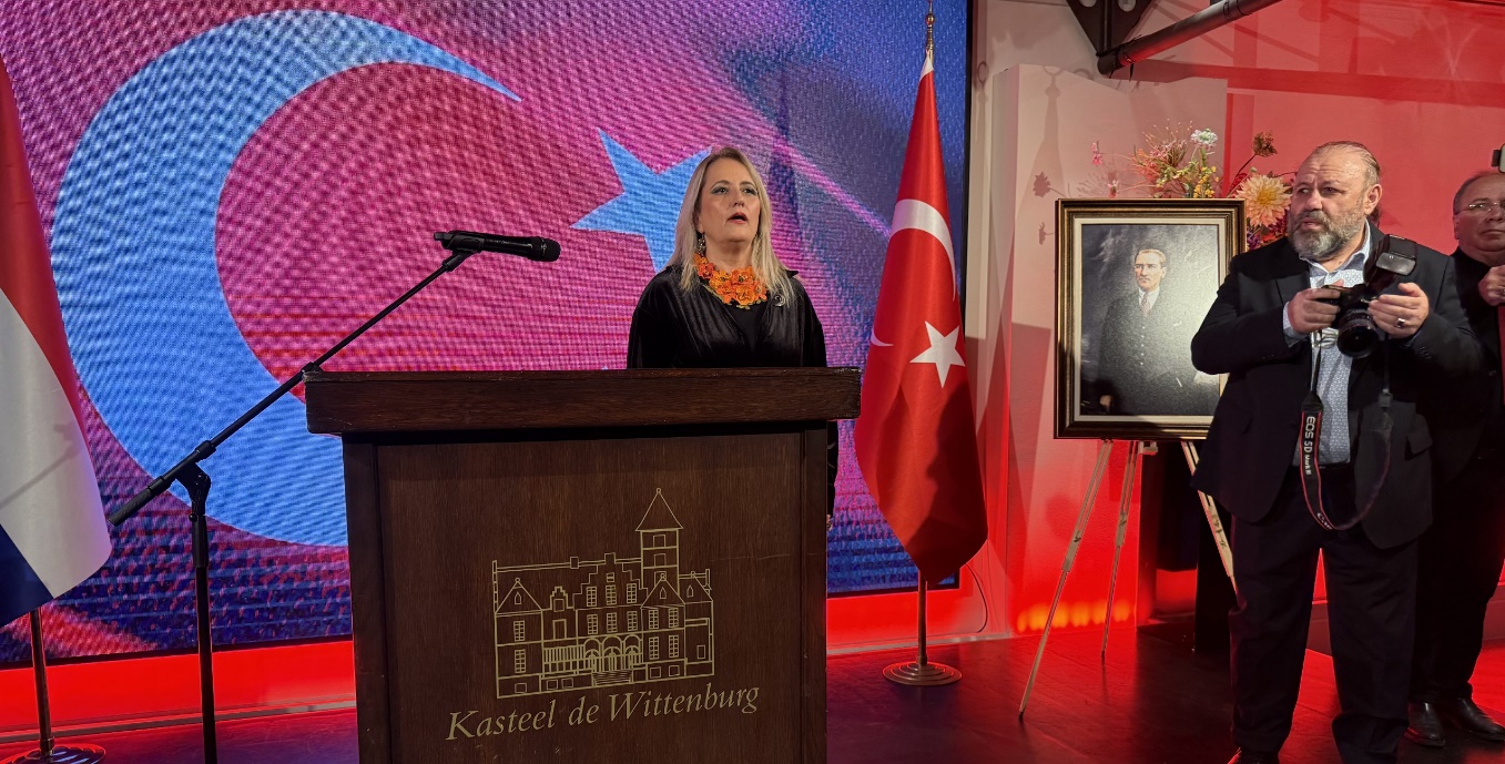 Afbeelding met kleding, microfoon, pak, persoon Door AI gegenereerde inhoud is mogelijk onjuist.