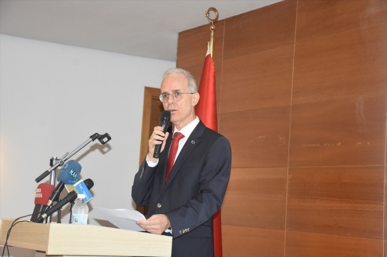 Afbeelding met microfoon, muur, kleding, persoon Door AI gegenereerde inhoud is mogelijk onjuist.