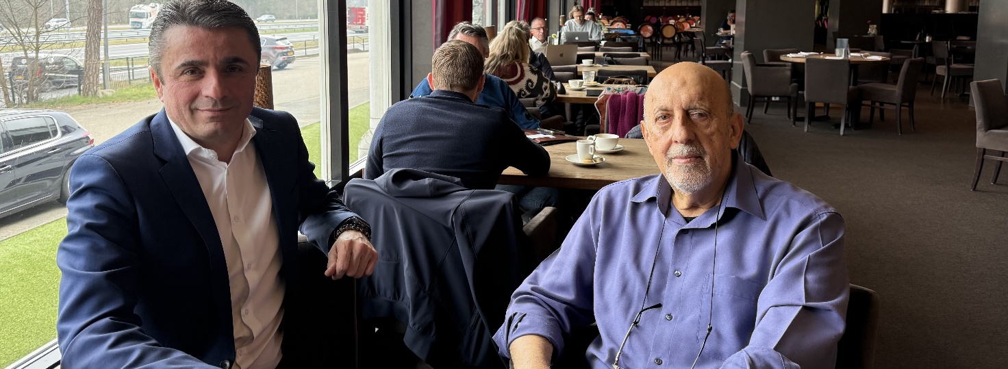 Afbeelding met kleding, persoon, Menselijk gezicht, pak Door AI gegenereerde inhoud is mogelijk onjuist.