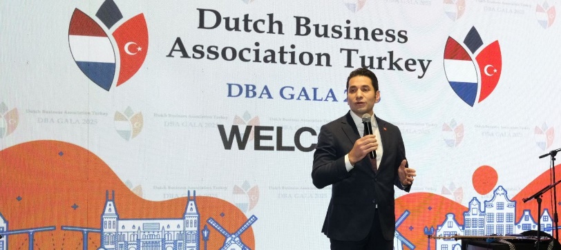 Afbeelding met tekst, kleding, microfoon, pak Door AI gegenereerde inhoud is mogelijk onjuist.