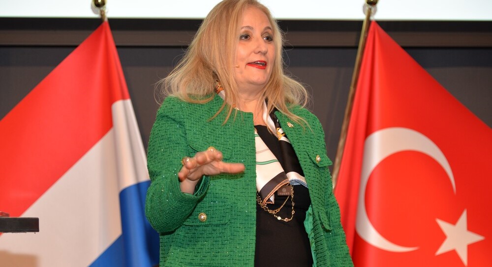 Afbeelding met kleding, Menselijk gezicht, persoon, microfoon Door AI gegenereerde inhoud is mogelijk onjuist.